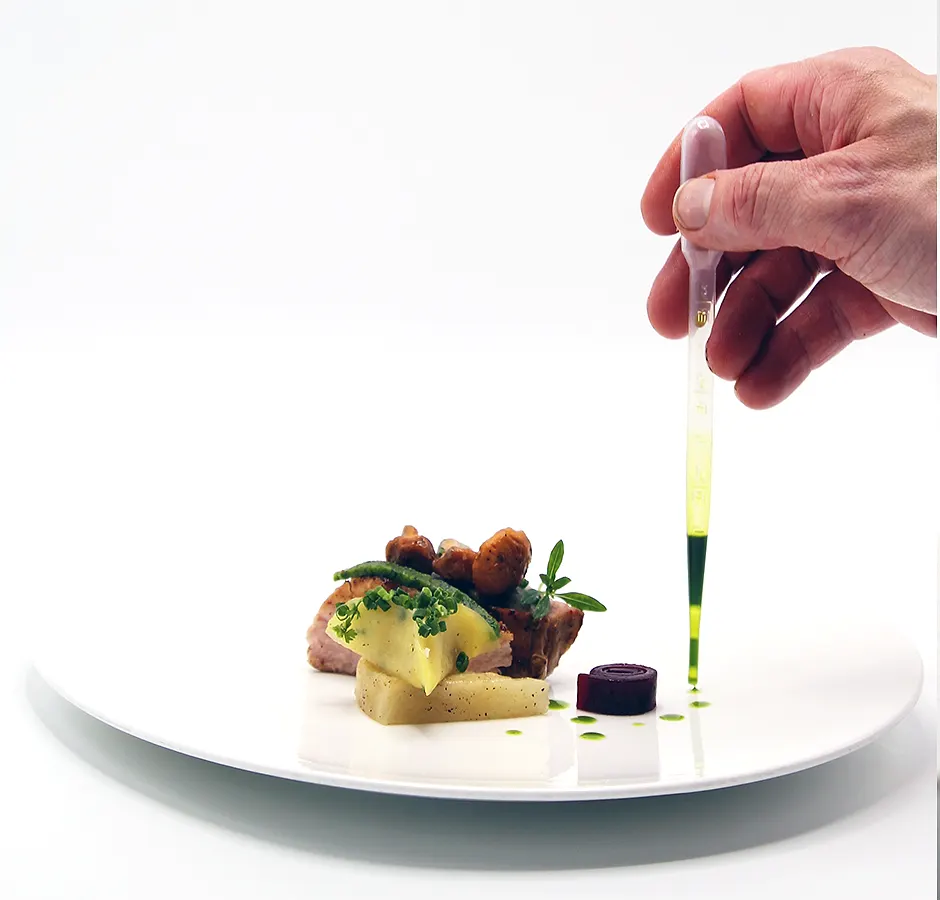 Een gerecht wordt met een pipet afgewerkt